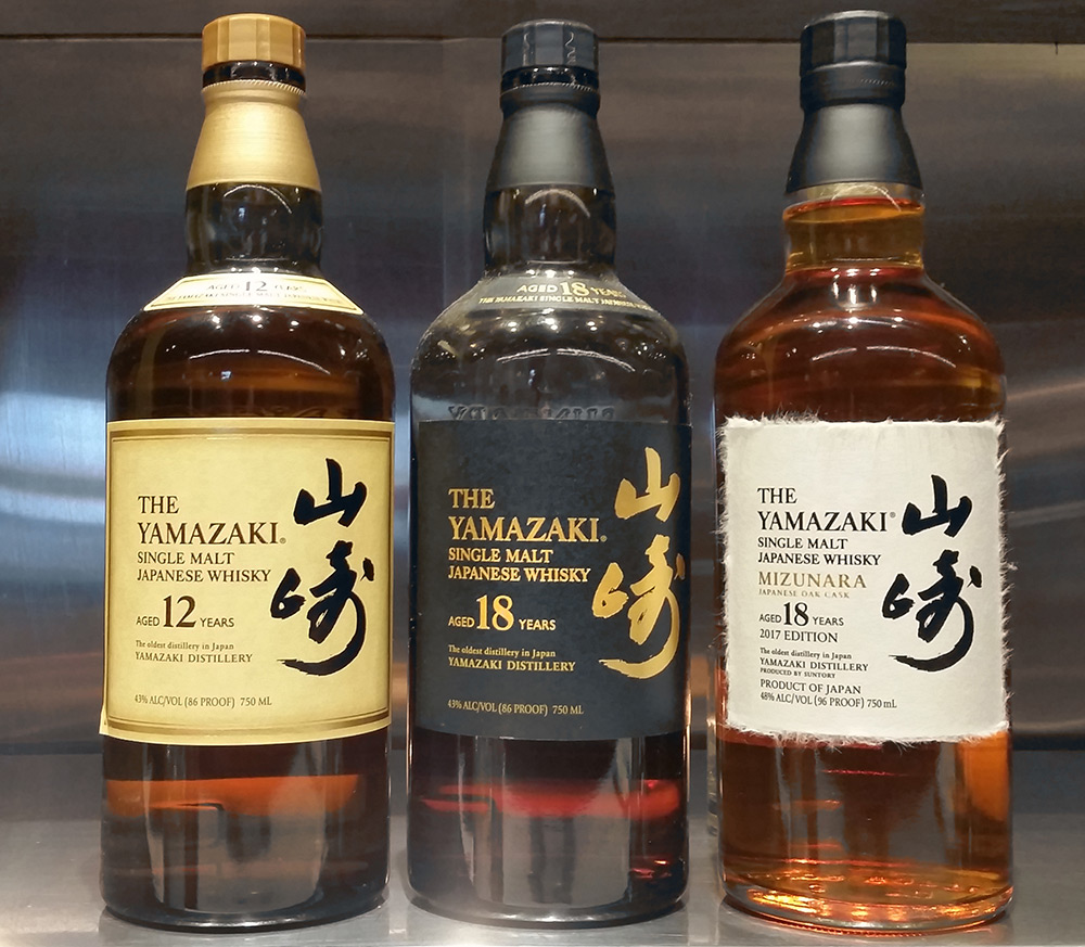 Three bottles of Japanese whiskey on a metal shelf