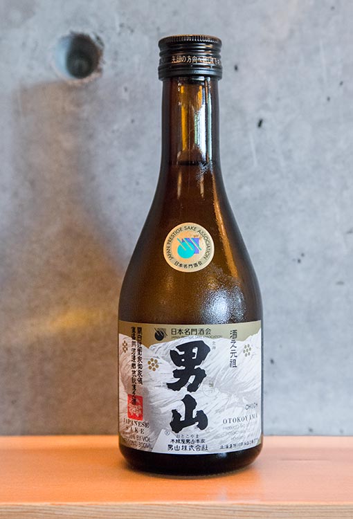 a bottle of Hokkaido sake on a wooden shelf