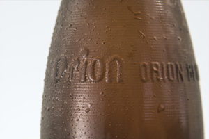 Orion embossed brown glass beer bottle.