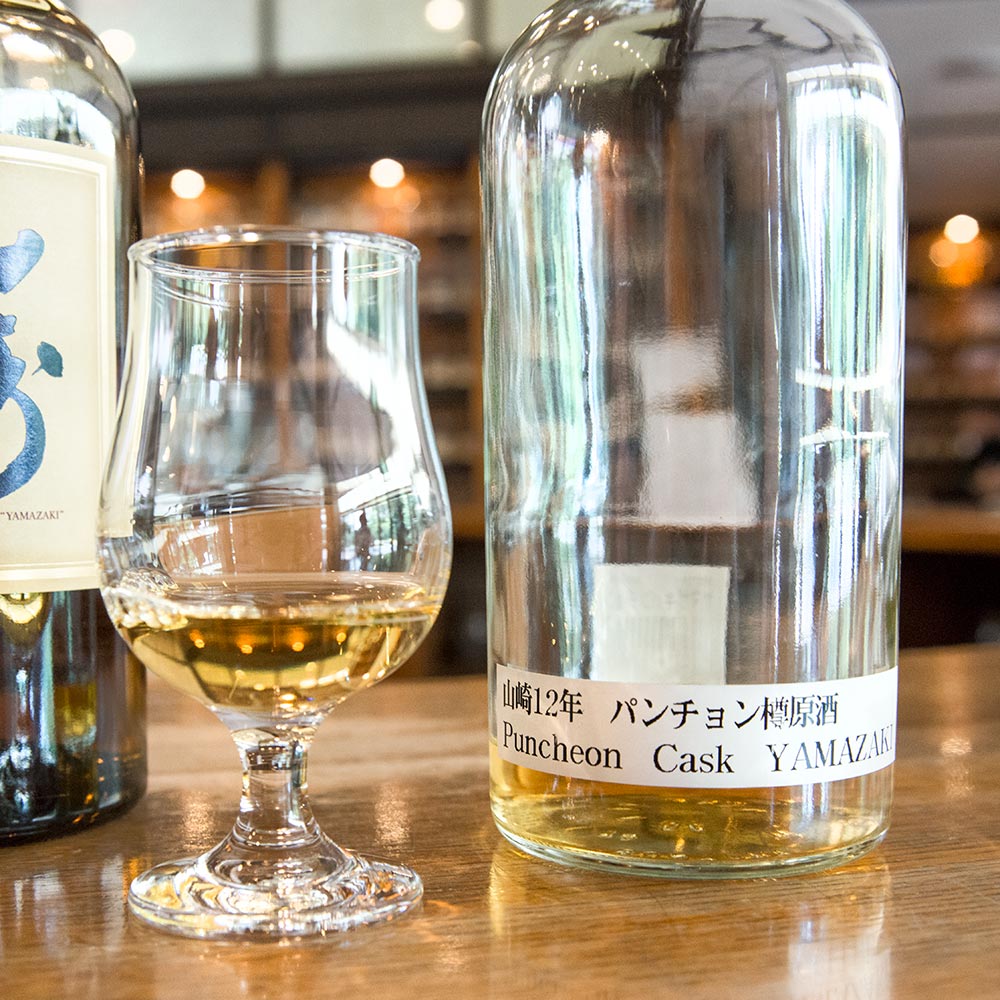 A tasting glass and plain bottle of rare Yamazaki whisky.