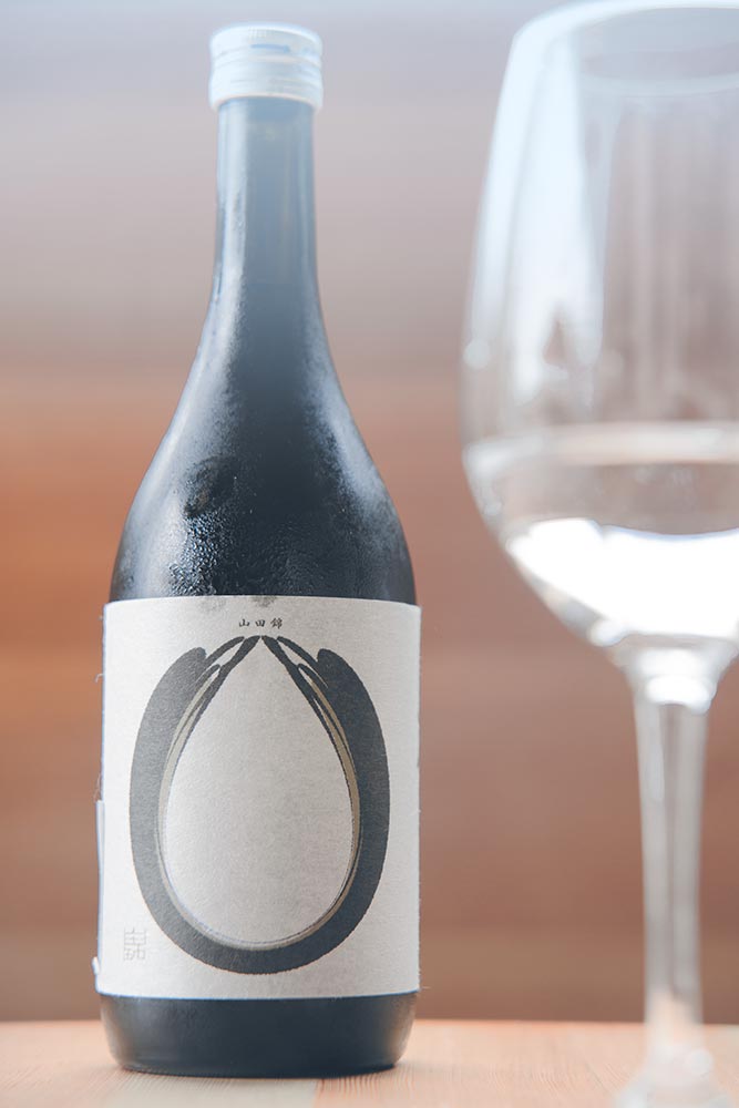 A bottle of Junmai Daiginjo sake and a wine glass.