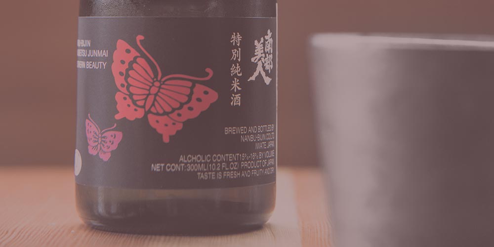 A close up of Nanbu Bijin sake and cup.