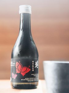 A bottle of Iwate sake and a ceramic guinomi cup.