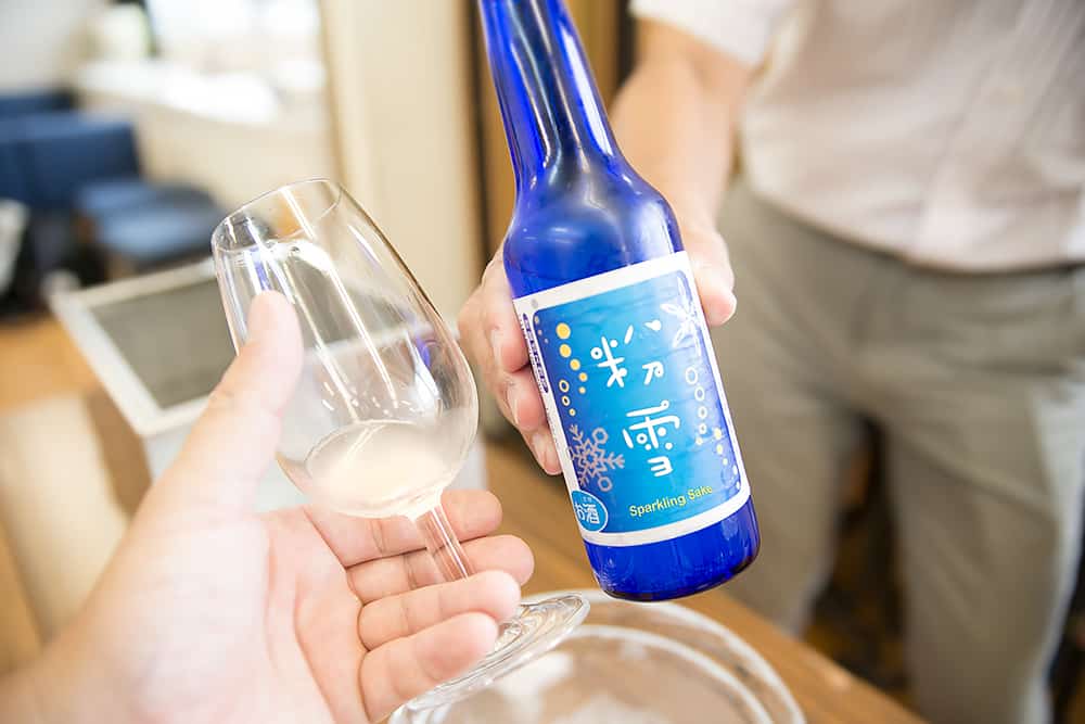 a bottle and glass of sparkling nigori sake