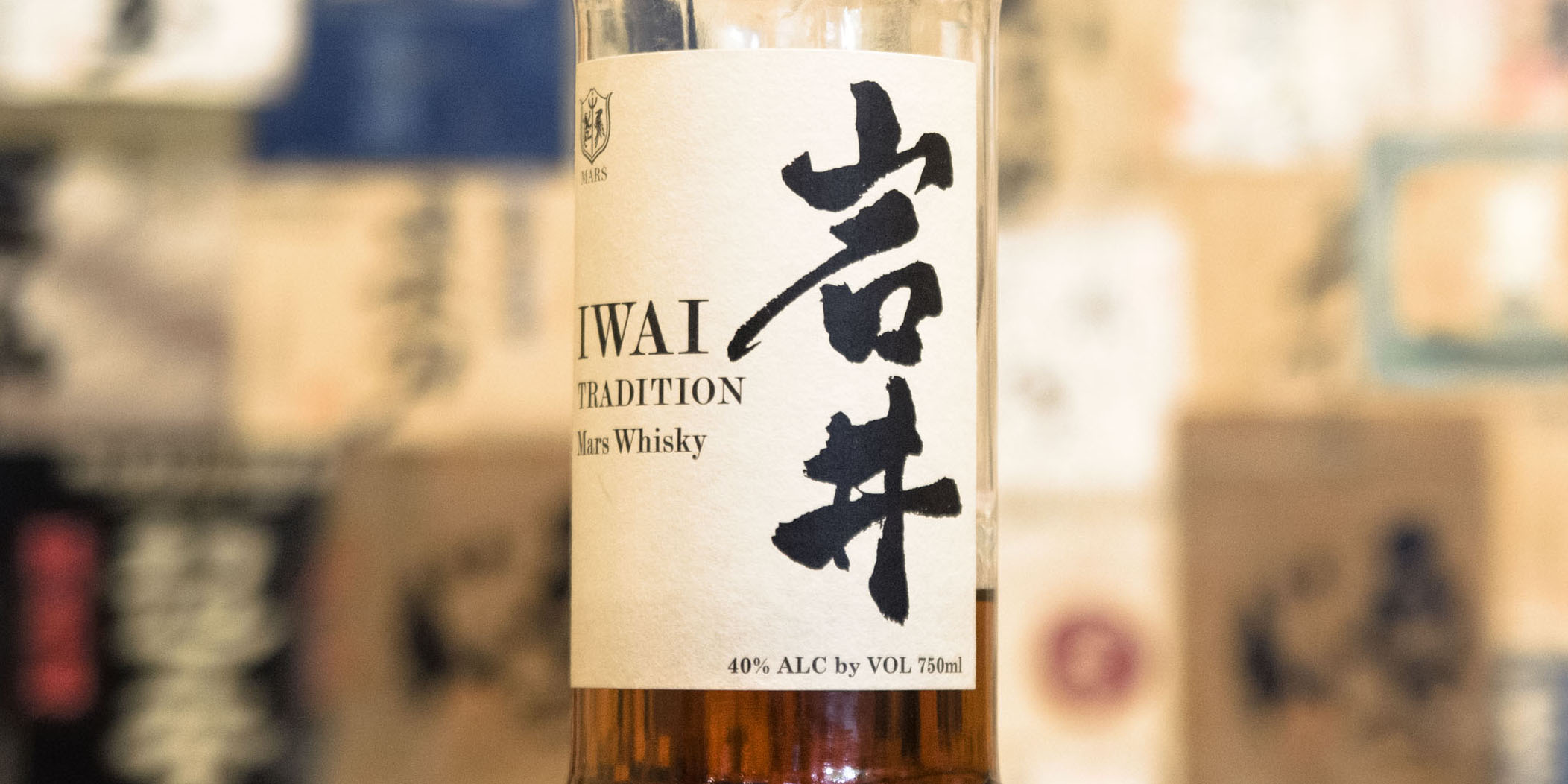Close up of a bottle of Mars Whisky in a colorful izakaya.