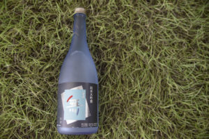 a bottle of sake lying on the grass