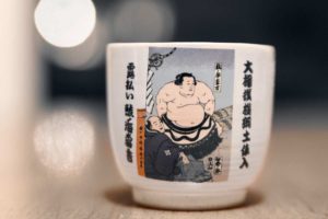 a sake cup with an illustration of a sumo wrestler