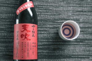 a bottle of sake and a sake cup with a bullseye