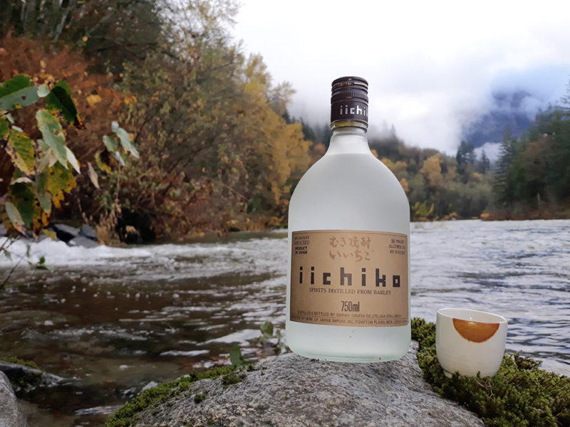 A bottle of Iichiko Honkaku Barley Shochu a mountain river.