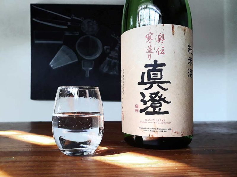 bottle of sake with dirty label and a clear glass