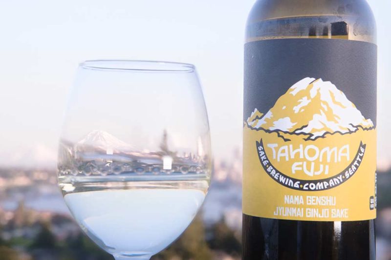 sake in a wine glass with a reflection of Seattle and Mt Ranier