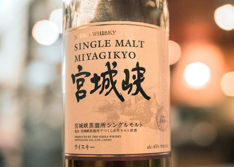 A bottle of Japanese whiskey in a well-lit bar.