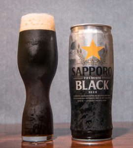A can of black Japanese beer and a full Pilsner glass.