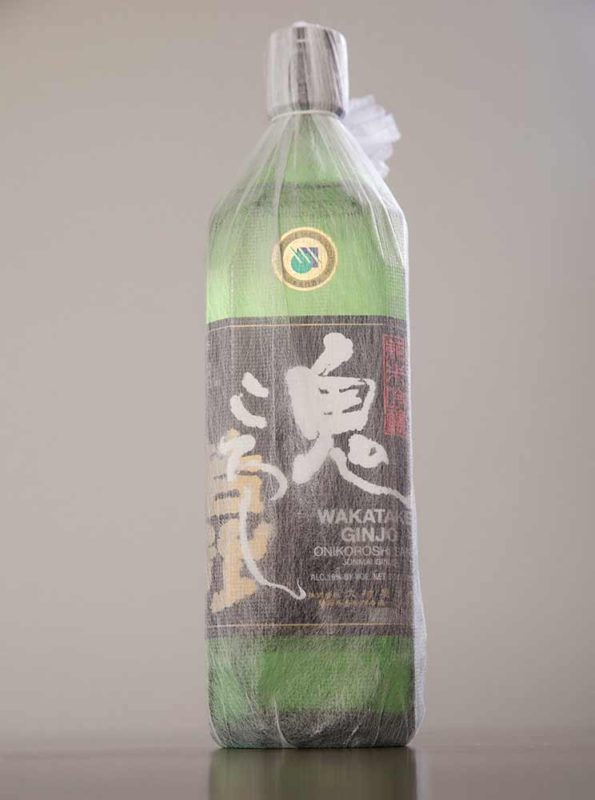 A green bottle of sake with a black label.