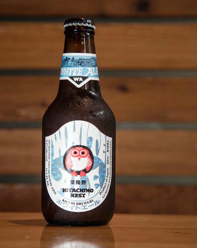 A blue bottle of Japanese beer in a wooden room.