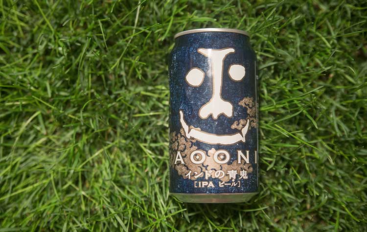 A blue can of Japanese IPA on the grass.