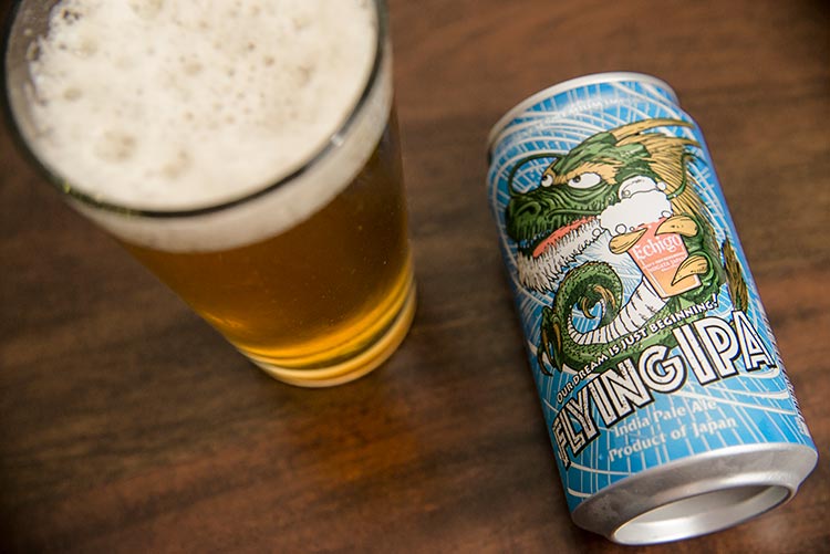 a can of beer with a dragon logo and a full glass