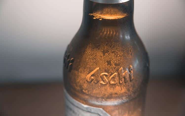 an embossed Asahi logo on a brown bottle of beer
