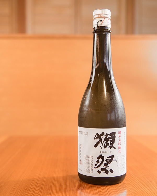 a bottle of Dassai sake in a wooden kappo-style restaurant