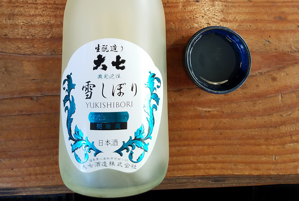 a bottle and cup of nigori sake