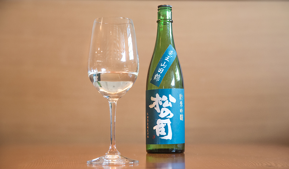a blue bottle of Shiga sake and a wine glass