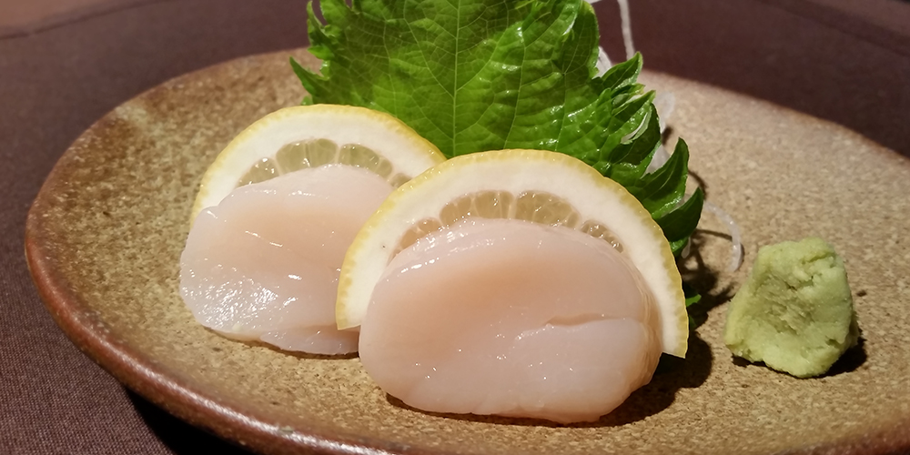 two slices of scallop sashimi