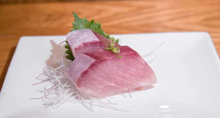 two slices of yellowtail sashimi