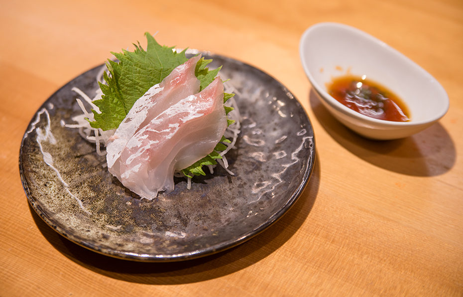 two slices or seabream sashimi with ponzu sauce