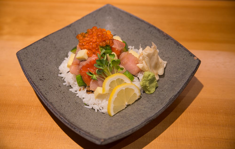 a chirashi bowl with ikura, salmon, yellowtail, and tamago