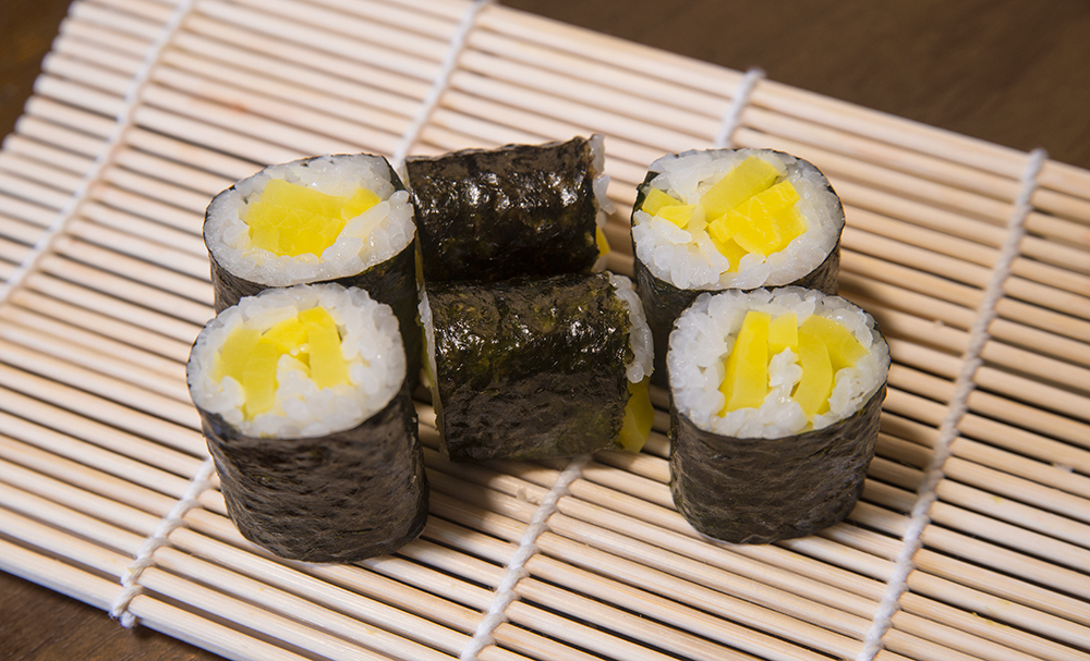 a oshinko sushi roll on a makisu