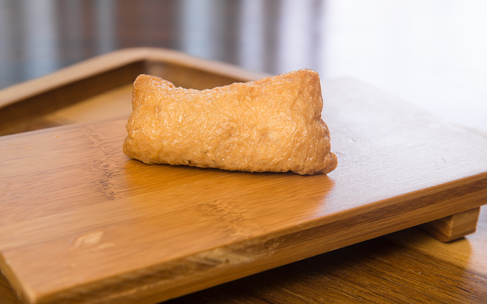 inari sushi on a bamboo plate