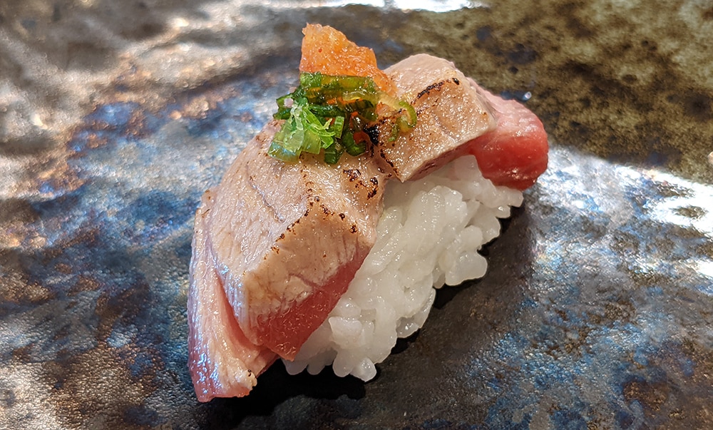a piece of seared otoro nigiri sushi