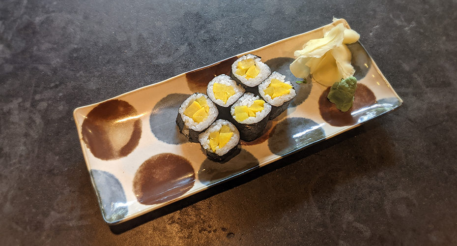 a six piece oshinko roll on a Japanese plate
