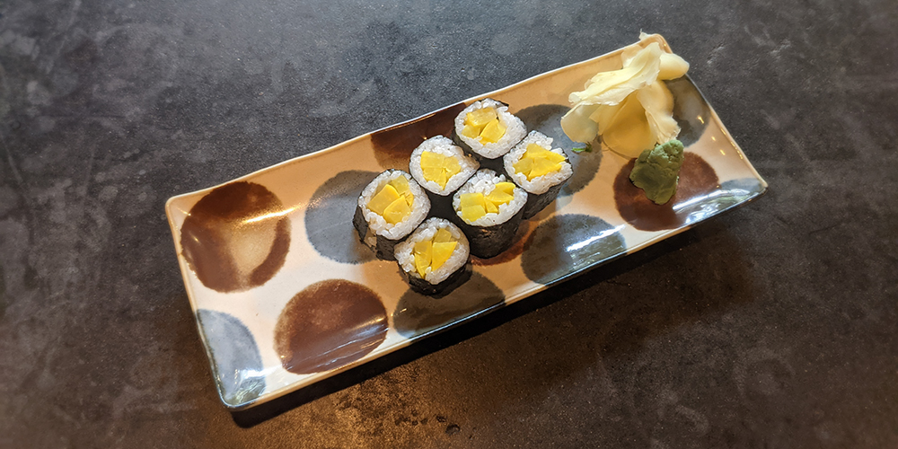 a six piece oshinko roll on a Japanese plate
