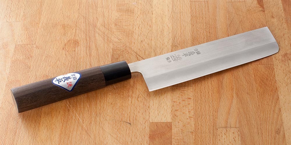 a Japanese vegetable knife on a cutting board