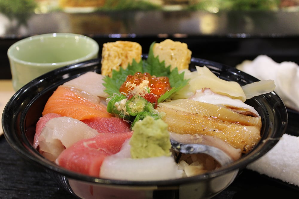 a chirashi bowl with many types of seafood on top