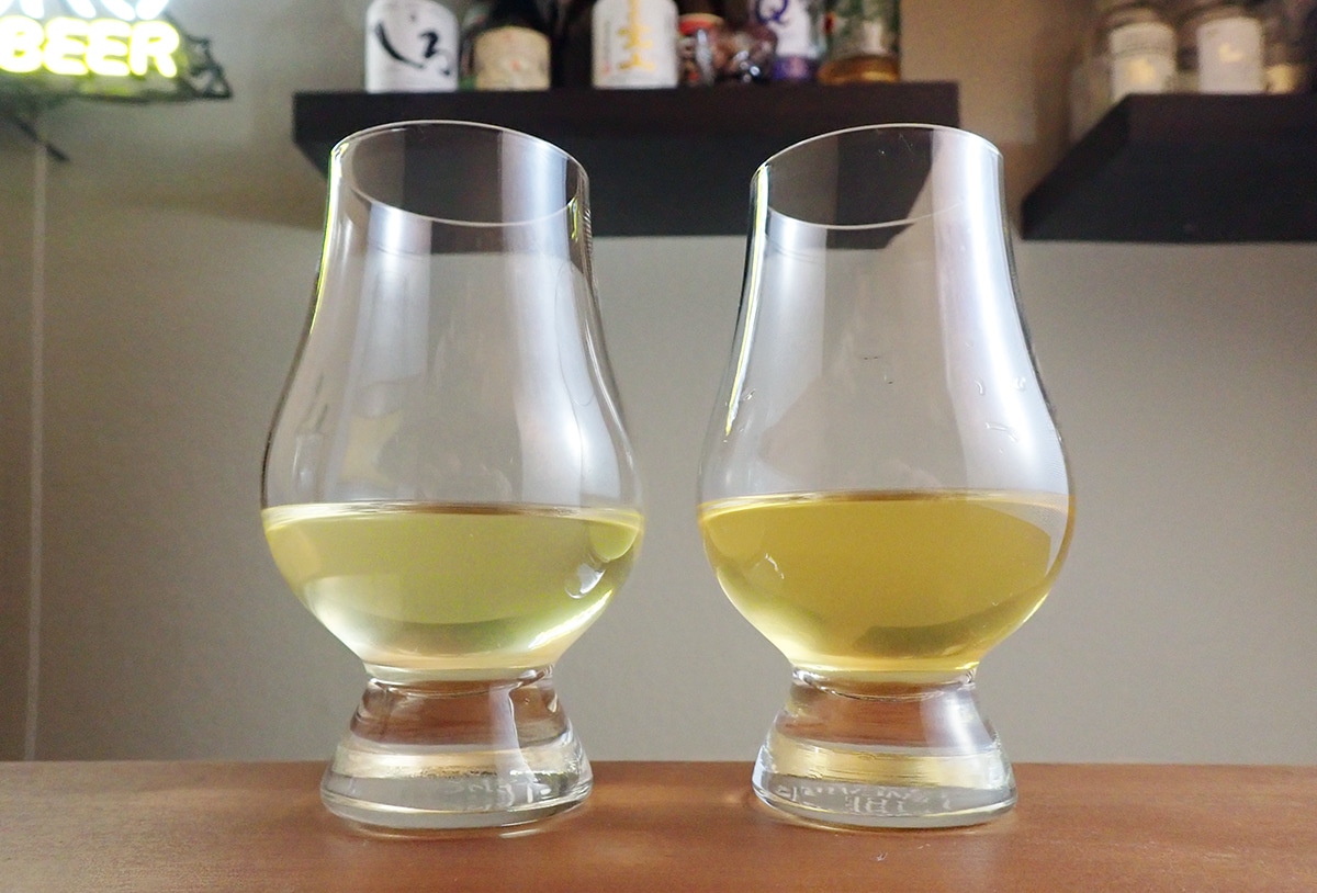 two tasting glasses with greenish-gold alcohol