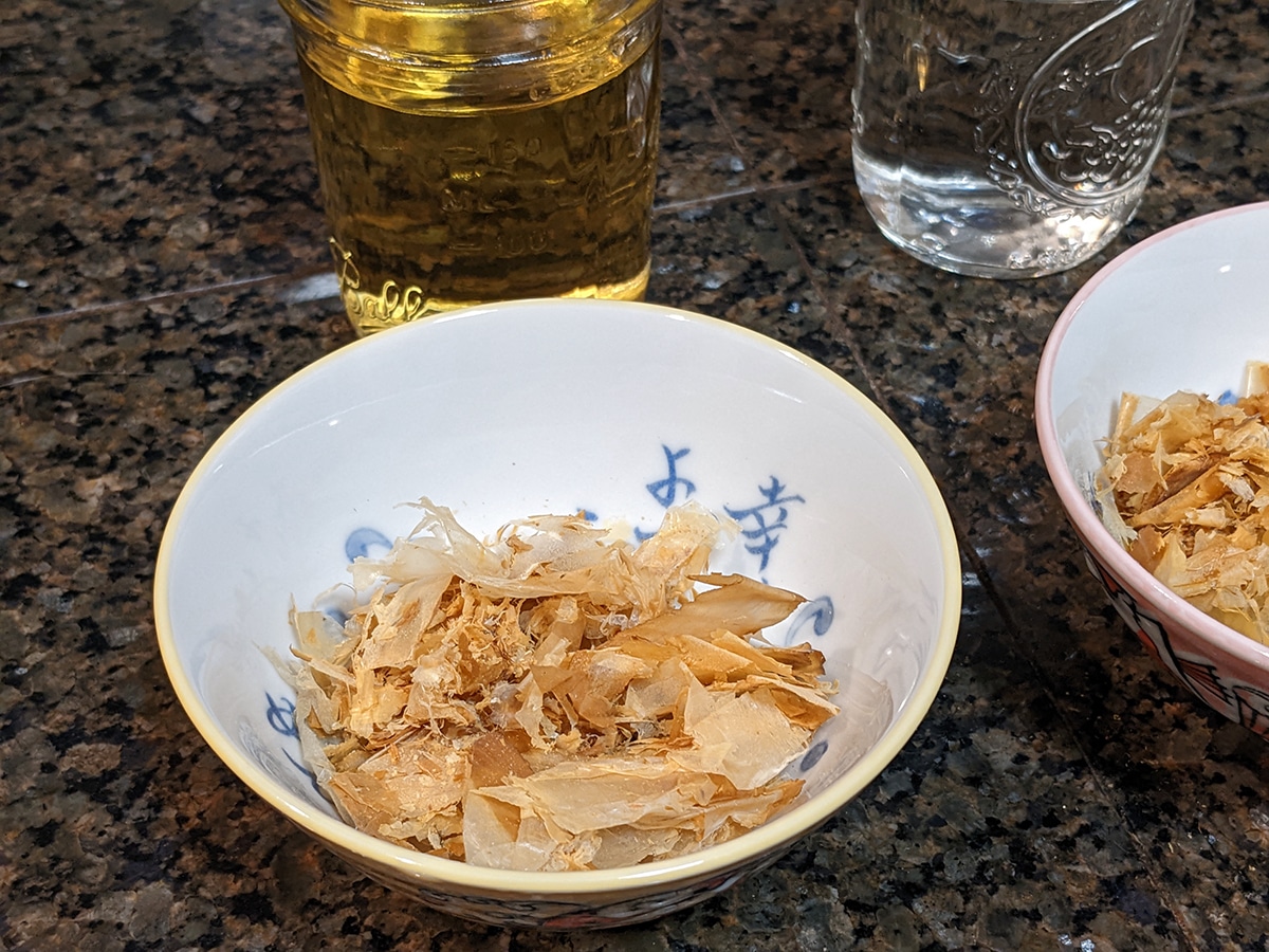 a bowl of bonito flakes with whisky in the background