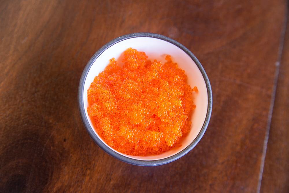 a small bowl filled with bright orange fish roe