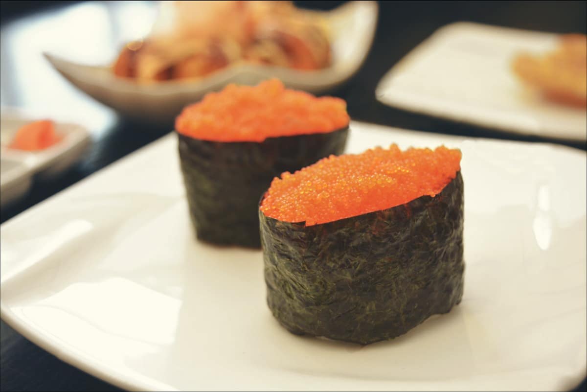 two pieces of fish roe sushi on a plate