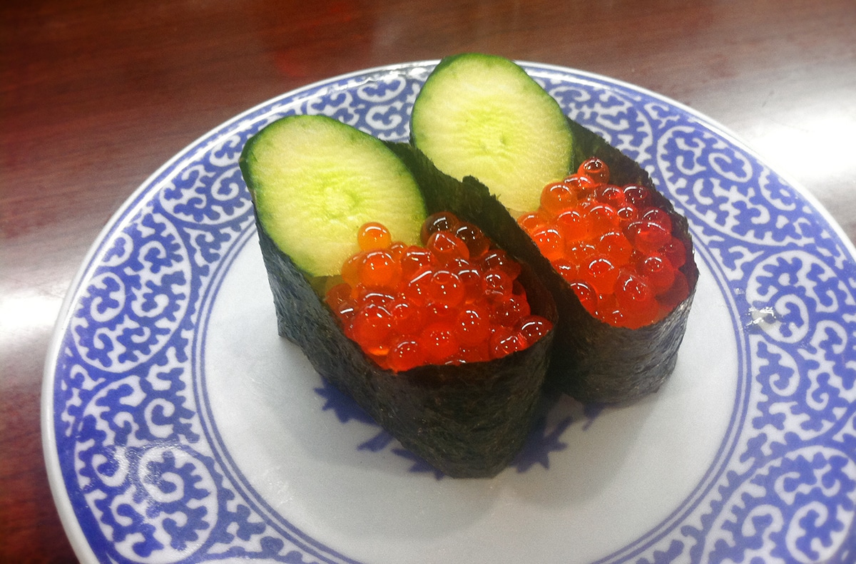 two pieces of salmon roe sushi with cucumber slices