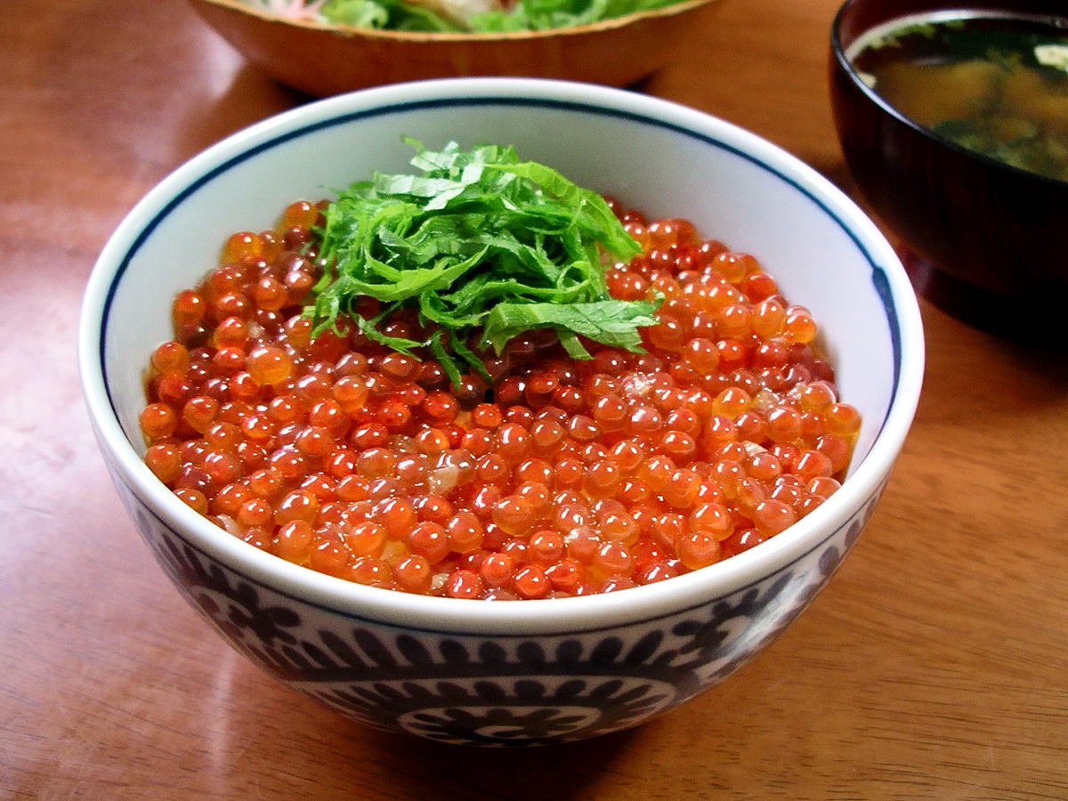 a large bowl of rice with salmon eggs on top