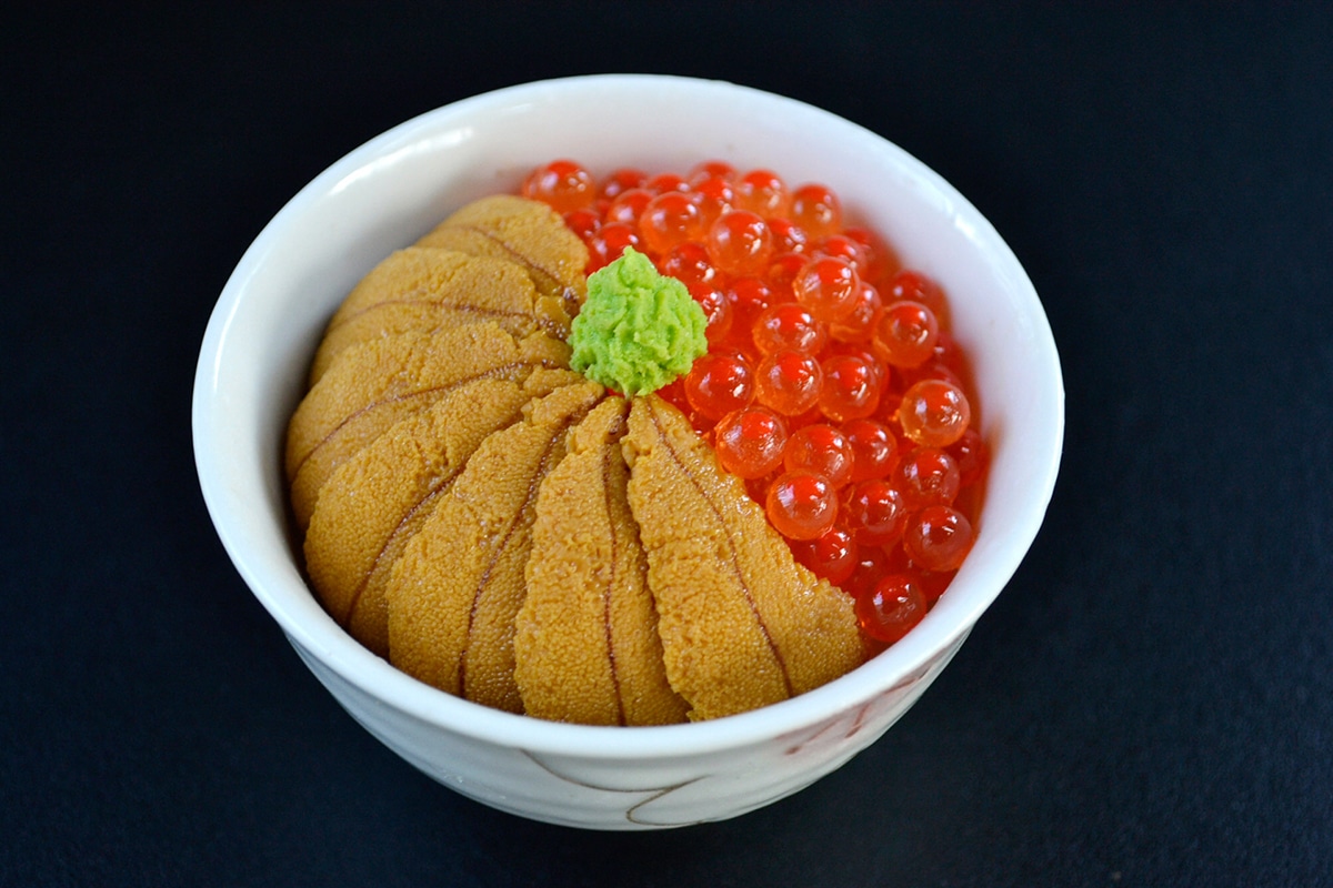 a bowl of rice, uni, and salmon roe