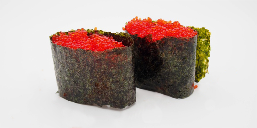 two pieces of red tobiko sushi