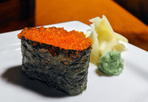a piece of flying fish roe sushi