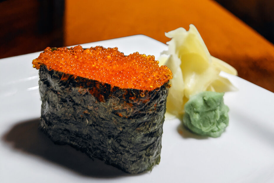 a piece of flying fish roe sushi