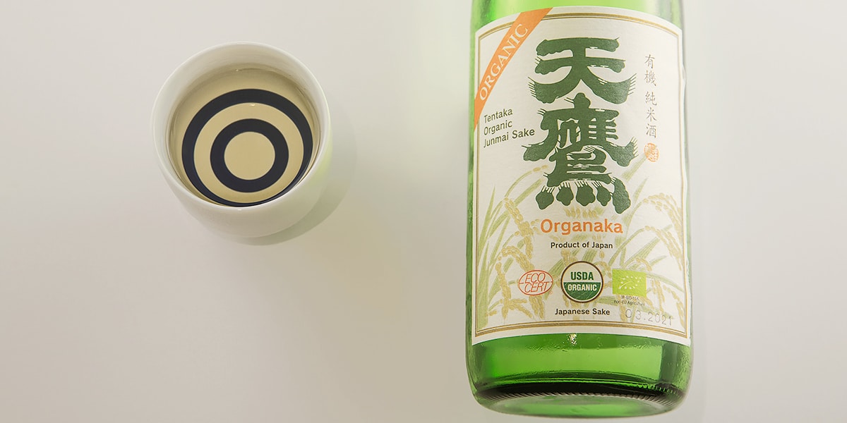 a bottle of organic sake and a janome cup