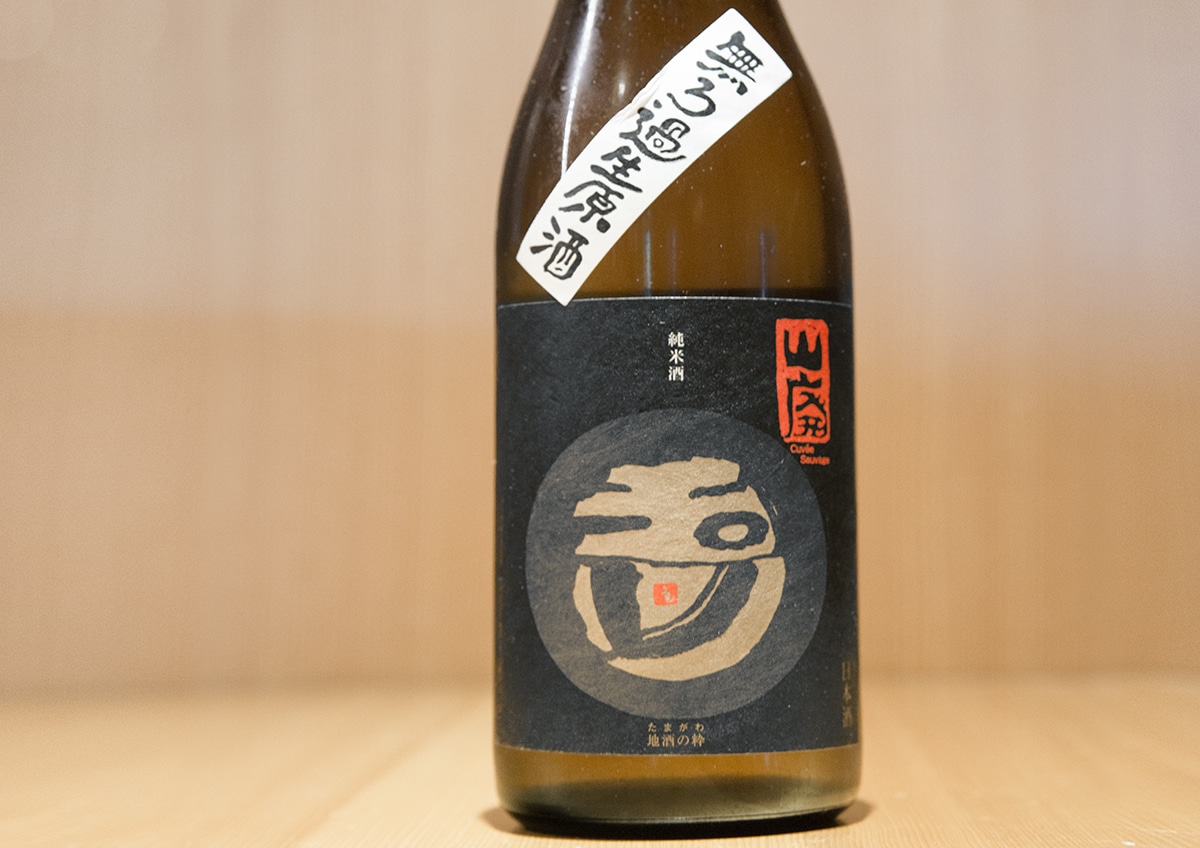 a bottle of Tamagawa sake in a wooden kappo restaurant